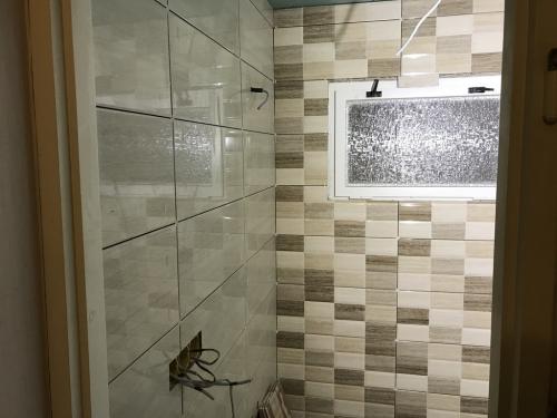 Fürdőszoba falburkolat: 60 x 25 cm-es fényes burkolólapok