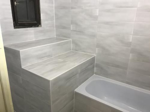 Kifugázott fürdőszoba burkolat: penészedés gátlóval készült fehér fugával