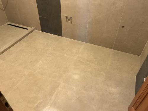 Fürdőszoba padlóburkolat: 60x60 cm-es gres porcelán burkolat, holdfehér fugával